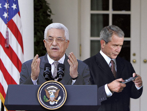 President Bush and Prime Minister Abbas - President Bush is seen at what appears to be texting on his cell phone while the Prime Minister Mahmoud Abbas presents a public speech. 