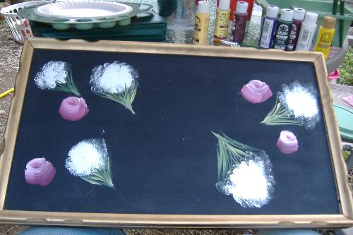 Progress on yard sale find table - This is a picture of what my table looks like so far. This is merely the top of it (the legs are laying elsewhere waiting for me to finish the top). I have done One Stroke painting on it--rosebuds and Queen Anne's Lace. Not sure what else I am doing on it--though I am hoping to put a big cabbage rose (in color to match the rosebuds) smack dab in the center. Just need to get those petal strokes down first LOL