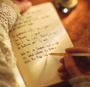 writing a book - person's hand writing a book