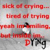 depression - greyscale photo of a girl crouched in a corner of a plain cement room. Words say, 'Sick of crying... tired of trying yeah I'm smiling, but inside I'm Dying.'