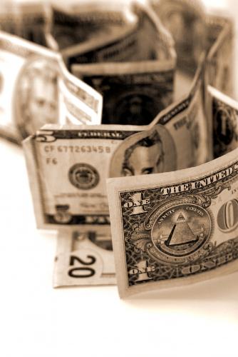 Folded money. - American dollar bills that have been folded up and spread out on a white surface.