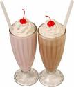 Milkshake - A picture of two milkshakes in glass cups. A chocolate milkshake with whipped cream and a cherry on top. A strawberry milkshake topped with whipped cream and a cherry.