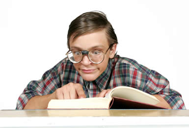 nerd - nerd sitting and reading a book with humungous glasses and a goofy smile on his face