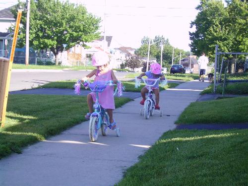 biking kids - my daughter and her best friend biking on the sidewalk