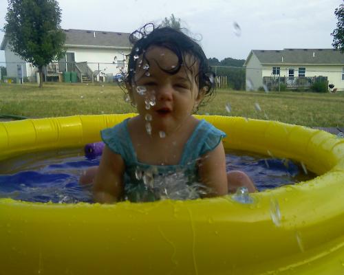 Splashing Around - The photo contest is "Water Babies" so we entered this photo of her splashing around in her little pool.