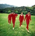 Guster - members of guster wearing all read on a grassy field