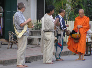 Giving - Men giving alms to the monks
