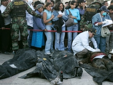 corpses - The forensic expert. examines bodies of earthqueake victims as people look on, in Pisco, Peru, Friday August 17 2007.