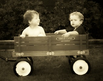 My boys in a wagon-sepia - My two middle boys riding in the wagon. I cropped it to center them, altered the lighting to highlight them and darken the background, and then changed it to sepia.