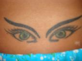 Dina's Tattoo - This is a pic of my tattoo on my lower back. It is a tattoo of my eyes. The tattoo had to take his time because he wanted to make the tattoo has original as possible so in order to this he had to keep looking at my eyes and then go to designing the tat on my back. This took time to make sure the eye color was precise.The artist died of a drug overdose, I did not even know he was doing drugs. I found out while I was living here in Florida he died doing a speedball. His work still lives on...my back. I lost a lot of my original pics when I relocated to Florida including the ones I had taken when the tat was fresh. It looked awesome with the redness all around it and the special shinyness but I had the tat retaken its notv the same from the first day but its still my tat. My computer crashed with all my pic files and they could not be retrieved. I have lots more to that story I would love to share.