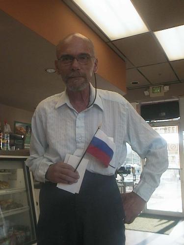 My Fiance Holding A Russian Flag - We ordered flags to put on our wedding cake, and they arrived today. Here he is holding the Russian flag. My flags are for Denmark and Canada, and his are for the USA and Russia, thereforew we are having a red, white and blue wedding.