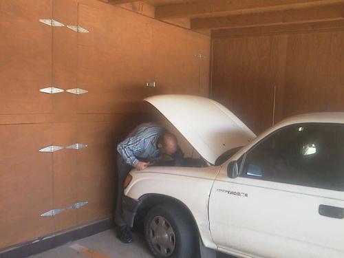 'What's Wrong With My Truck?' - Here's my fiance trying to figure out what is wrong with his truck, the other moning. After some work, he realized the battery cable had broken. He pushed it back together and held it in place with a bent coat hanger, so he could drive into town and purchase a new battery cable.