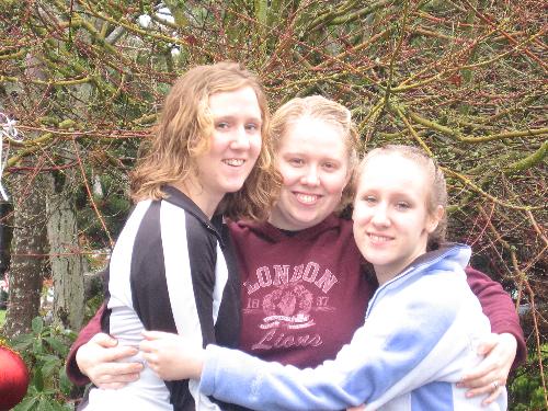three sisters - three young sisters standing outside smiling