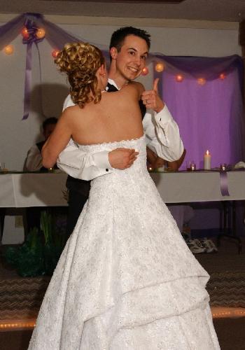 dancing wedding couple - a bride and groom dancing at their wedding. the groom is giving the camera a thumbs up