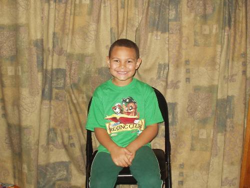 My oldest grandson - He's sitting in front of curtains that we made to cover the books on the bookshelves so it would make it look less cluttered in the living room. It also gives us a nice background for picture taking for the kids.