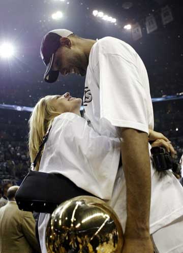 celebration embrace - After the finals, to celebrate the win of title, Tim was given a hug by his wife Amy, with a childlike smile on his face.