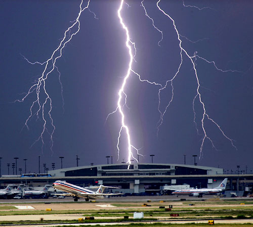 Last Flight out - A bolt of lightning beyond the terminals as an American Airline Jets takes off from Dallas/Forth Worth International Airport, as an approaching storm passes by.  Tom Fox/The Dallas Morning News