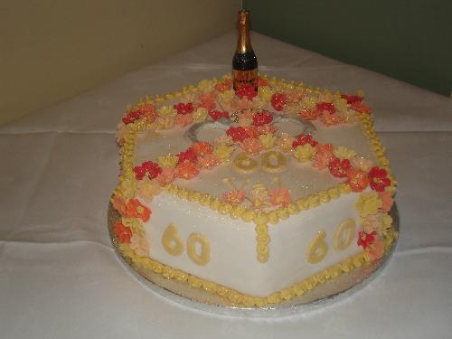 The Cake - Val's 60th Birthday Cake. Autumn coloured flowers, champagne candle and handcuffs. lol