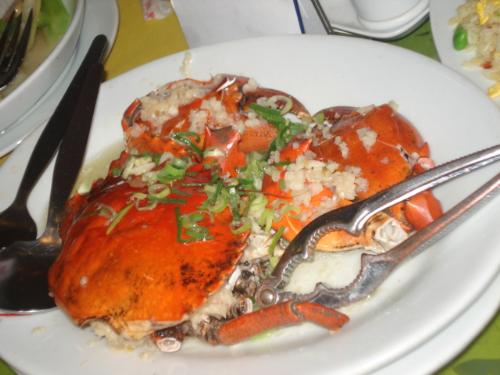 crabs - Delicious spicy crab on a plate with garnish on top.