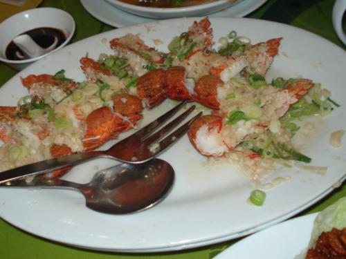 lobsters - In this particular picture are several tasty lobsters topped with minced garlic and spices served on a plate.