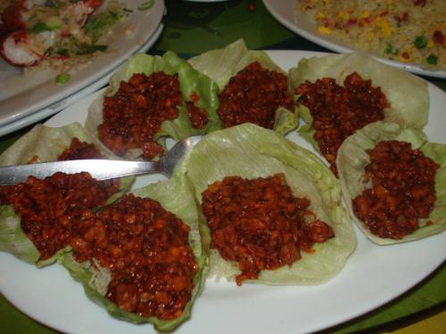 ground duck - In this particular photo are several servings of delicious ground duck meat on top of a few cut fresh lettuce.