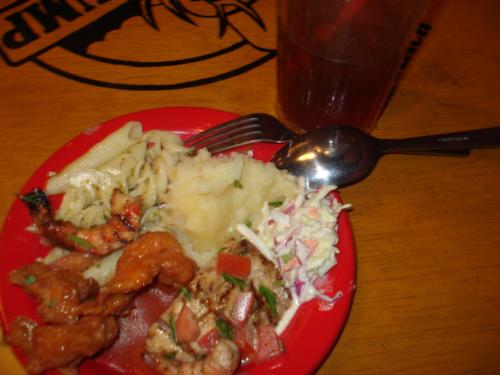 hearty meal - In this specific photograph is a piece of pizza, sweet and sour pork strips, sweet prawns, pasta, mashed potato, and coleslaw.