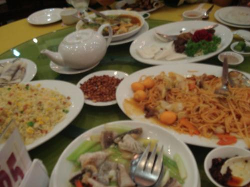 Chinese laureat - Fried rice, fish, squid, roasted duck, tea, nuts, duck shawarma, and condiments could be seen in this particular photo.