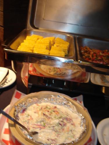 buffet - In this specific photo is several corns, chicken barbecue, and salad, which are all part of the buffet.