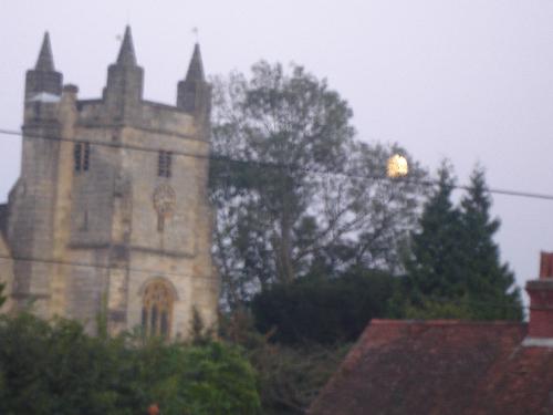 The Moon Rising Beside The Church - Almost full, the Moon rises behind a tree, beside the church.