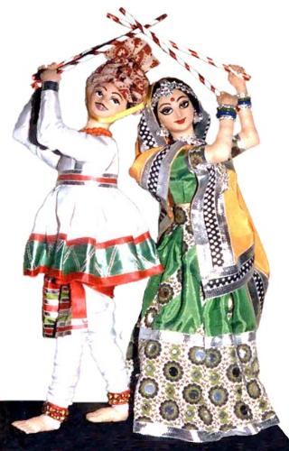 Dandiya Dance - This dance is a mock fight between Goddess Durga and the
mighty the demon king Mahisasura and is nicknamed the sword dance. The women wear traditional dresses studded with mirror works and heavy embroidery and men wear turbans and kedias but can vary from region to region. It is a very energetic dance. Dandiya Dance - This dance is a mock fight between Goddess Durga and the
mighty the demon king Mahisasura and is nicknamed the sword dance. The women wear traditional dresses studded with mirror works and heavy embroidery and men wear turbans and kedias but can vary from region to region. It is a very energetic dance.