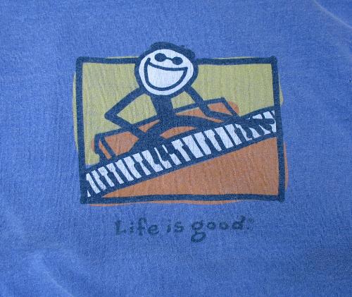 Life is great - This is a shirt with a person playing a piano and there is words saying: life is great!