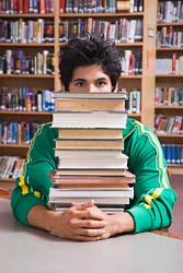 college kid with books - picture of a college semi-hot guy with tons of books in the library