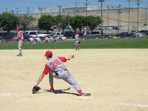 Me stretching to scoop a low throw - Me over at First Base stretching to field a low throw