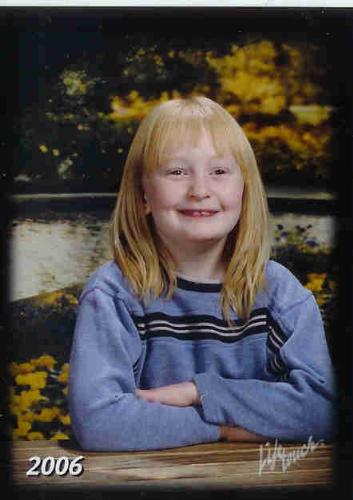 My daughter at 7yrs. - This is my daughter's spring picture from a couple years ago. Notice the background compared to the usual plain ones from the fall class pictures that are normally taken. Each year the background is different. These pics cost a lil more than the fall pics but are worth it to me.