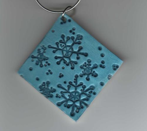 Snowflake Ornament - This snowflake ornament is made with polymer clay, stamped and painted with acrylic paint. The ornament was thencoated with a satin finish glaze for protection.