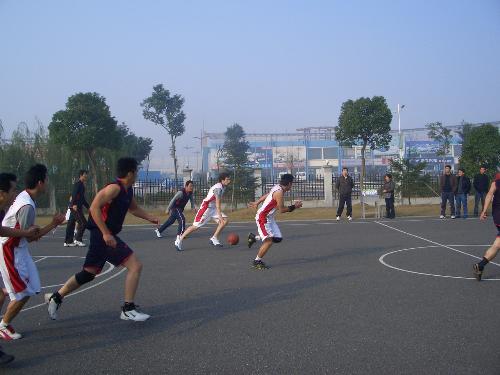 basketball playing on the court  - This picture shows that our team and another team is playing basketball. Ours wear white sportswear.