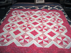 A pink quilt - This shows a pink quilt covering a bed