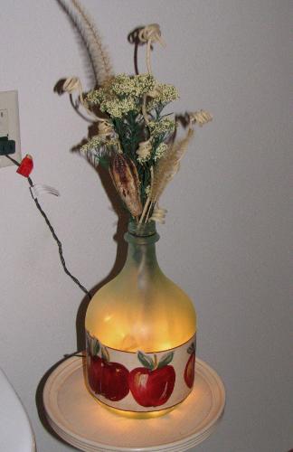 jug lights - Another of my crafty ideas using recycled items. This is a just lamp that makes a nice night light or TV light. They are made from gallon wine bottles sprayed with a frosted looking paint and then decoupaging wall paper border or material on it. A set of 25 miniture lights gives off a soft glow. Ya really need to be careful drilling a hole in the bottom of the jar as they break easy.