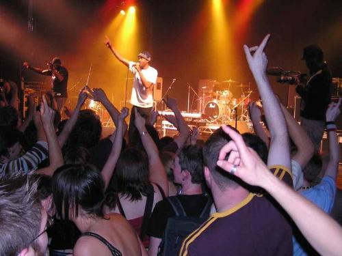 live music - A band on stage playing live to an audience in concert.  Playing music for the crowd, rocking the audience.  They are getting into the music on stage while they play live to an audience, a pretty big crowd at the rock n roll show.