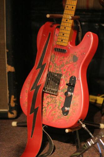 guitar - This is a red guitar.  An electric guitar for playing concerts for the audience.