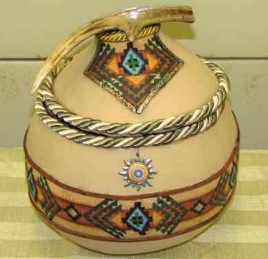 Southwest style gourd pot - I love making crafts and this gourd pot was so easy to make. After cleaning the outside off I cut across the gourd to remove the ball part on and then cut across the gourd again to make part of it the lid. Some paint, cloth, and cording gave it a beautiful southwest look.