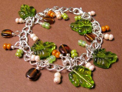 'Nature Lover' Bracelet - Green Glass Leaves and coffeebean shaped brown glass beads adorn this pretty charm-style bracelet.Ecru, moss green and terracotta colored accent beads complete this sterling plated bracelet. Available at my shop at Etsy. Clcik on my profile for the link to my shop.