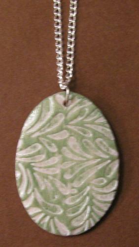 Sage Leaf Print pendant/necklace - Made with polymer clay and stamped w/ a Sage Leaf design. Stained w/ a whitewash and drybrushed with sage green acrylic paint. Pendant measures 1 1/2'x 1' (oval) and hangs on a 18' silver plated chain