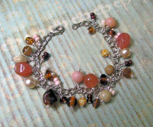'Cinnamon Struesel' Bracelet - A charm-style bracelet (7' in length) that is adorned with a whimsical combination of glass beads and faux pearls. The bead colors range from ecru to cinnamon and chocolate browns.