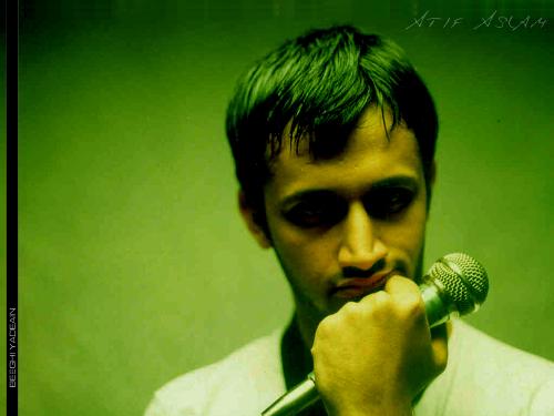 atif aslam - atif aslam in a green background.looking down. quite thoughtful.