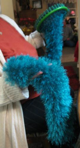 Magic Scarf - This is a scarf that was almost completed at the time the picture was taken. It is made from three skeins of fun fur in the color peacock on the green knifty knitter round loom.