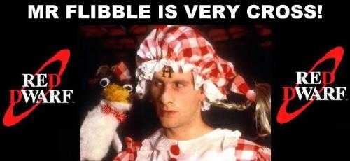 Mr Flibble is very cross - The insane Rimmer (from the Red Dwarf episode Quarantine)wearing a very fetching gingham checked dress and hat (with bunches) and demonstarting the Mr. Flibble puppet