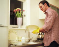 Washing dishes - Young man washing dishes with gloves