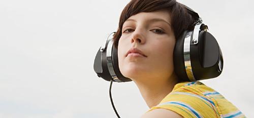 Listening to music - Young woman listening to music on roof