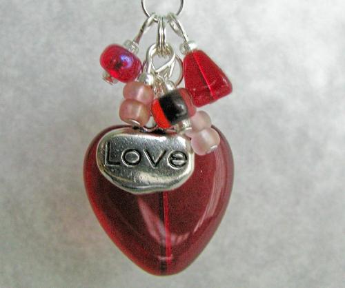 Love Cluster Necklace - A beautiful red glass heart focal bead hangs from the bottom of a cluster of red and pink beads.  A simple silver LOVE charm hangs from the cluster as well. The cluster is approx 1 3/4' and hangs on a 19' silver plated chain w/ a lobster clasp. Item SOLD the same day listed on ETSY.com